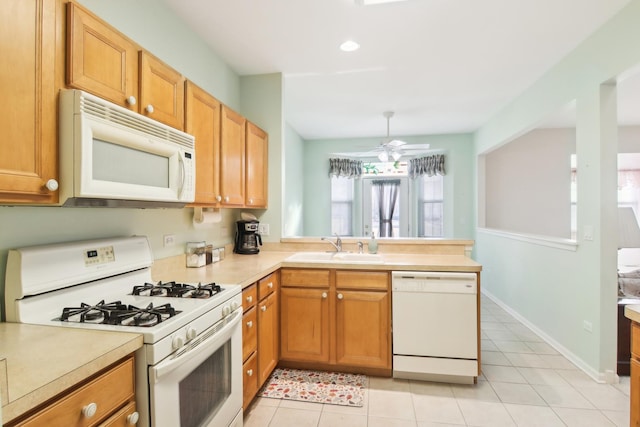 kitchen featuring light tile patterned floors, white appliances, a sink, baseboards, and light countertops