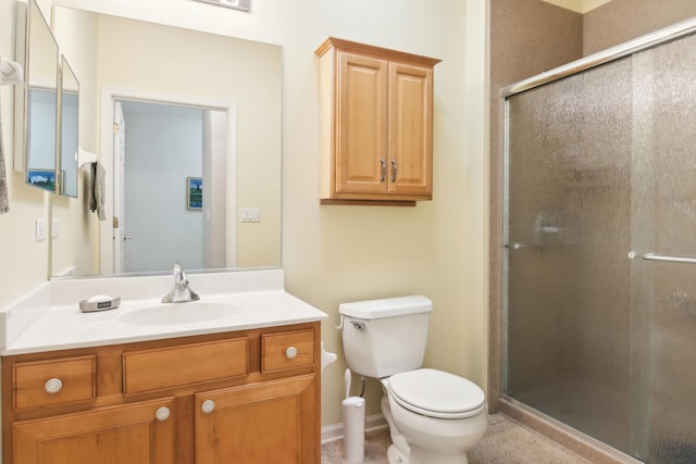 bathroom with a stall shower, vanity, toilet, and baseboards