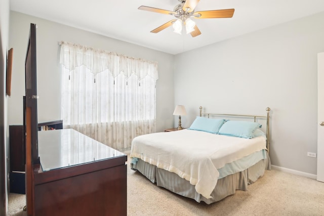 bedroom with ceiling fan, carpet, and baseboards