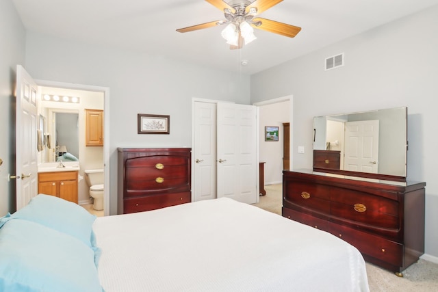 bedroom with ensuite bath, visible vents, baseboards, and light colored carpet