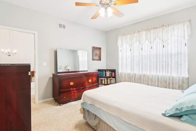 bedroom with baseboards, visible vents, carpet flooring, and ceiling fan with notable chandelier