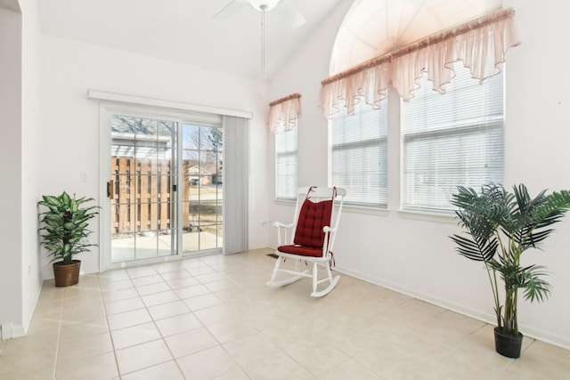 living area with lofted ceiling, ceiling fan, baseboards, and light tile patterned floors