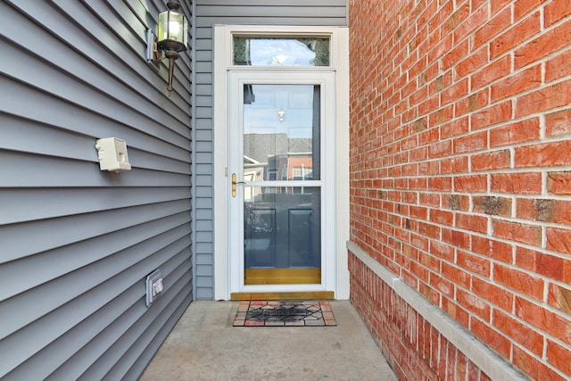 view of exterior entry with brick siding