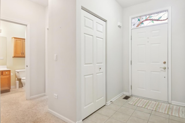 foyer with light tile patterned floors and baseboards