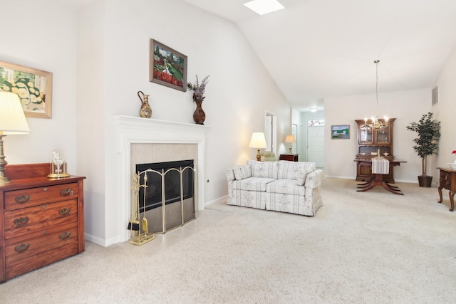 living area with visible vents, a tile fireplace, lofted ceiling, carpet flooring, and a notable chandelier