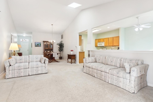 living room featuring light carpet, baseboards, visible vents, and ceiling fan with notable chandelier