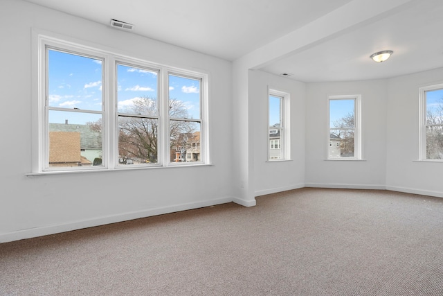 unfurnished room with carpet flooring, visible vents, and baseboards