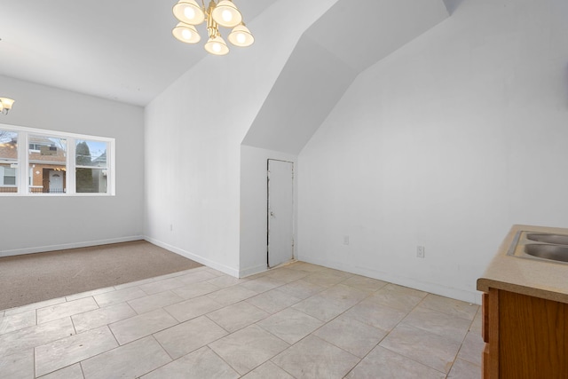 additional living space featuring baseboards, a sink, lofted ceiling, and an inviting chandelier