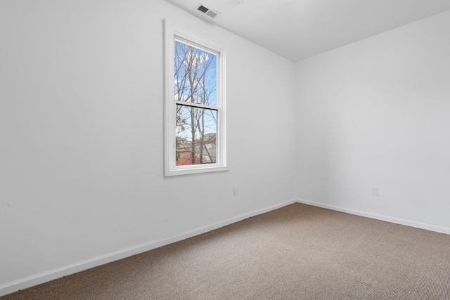 carpeted empty room featuring visible vents and baseboards