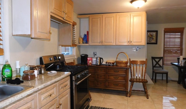 kitchen featuring light tile patterned floors, light brown cabinetry, and stainless steel gas range