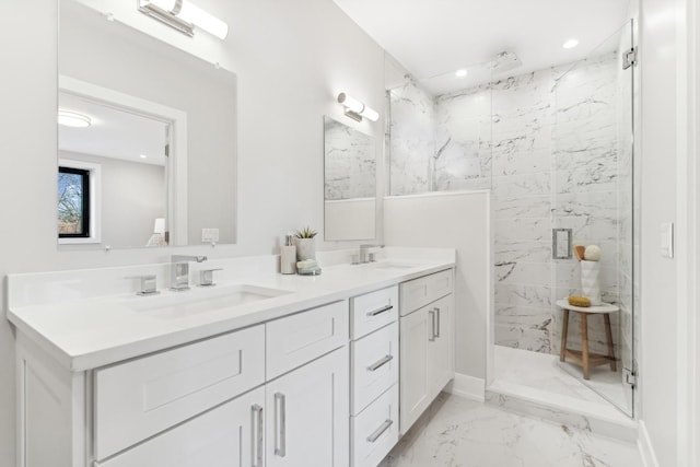 full bath with double vanity, marble finish floor, a marble finish shower, and a sink