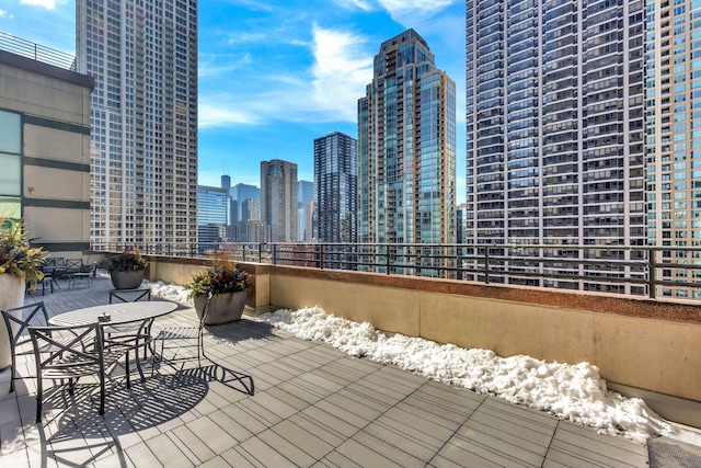 wooden terrace featuring a patio and a city view