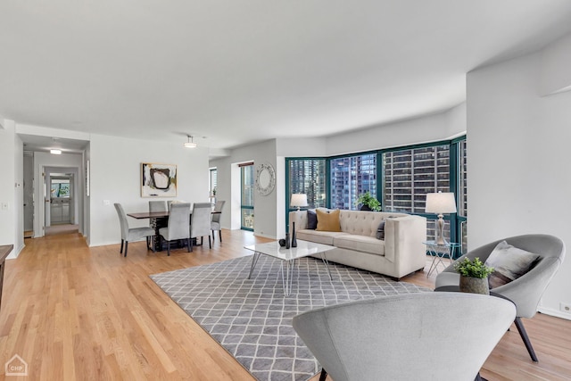 living room with baseboards, plenty of natural light, and light wood-style floors