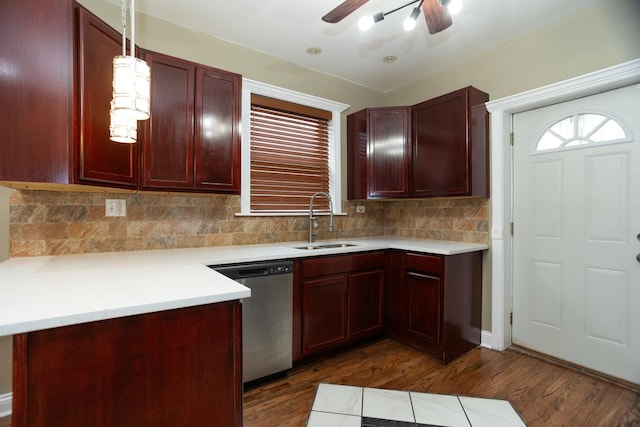 kitchen with reddish brown cabinets, dark wood finished floors, dishwasher, light countertops, and a sink