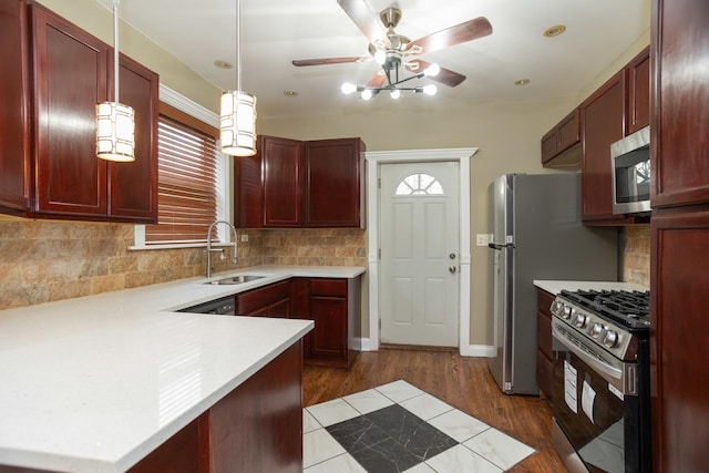 kitchen with reddish brown cabinets, stainless steel microwave, a sink, and range with gas stovetop