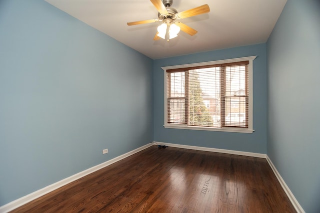 unfurnished room featuring dark wood-style flooring, ceiling fan, and baseboards