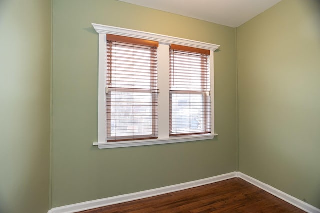 empty room featuring dark wood-style floors and baseboards