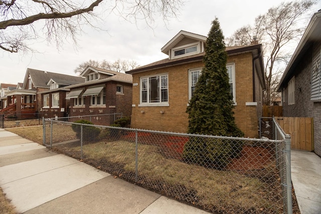 view of front facade with fence private yard and brick siding