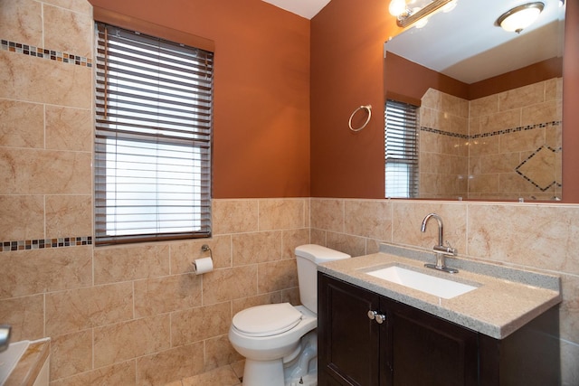 bathroom featuring toilet, a wealth of natural light, tile walls, and vanity