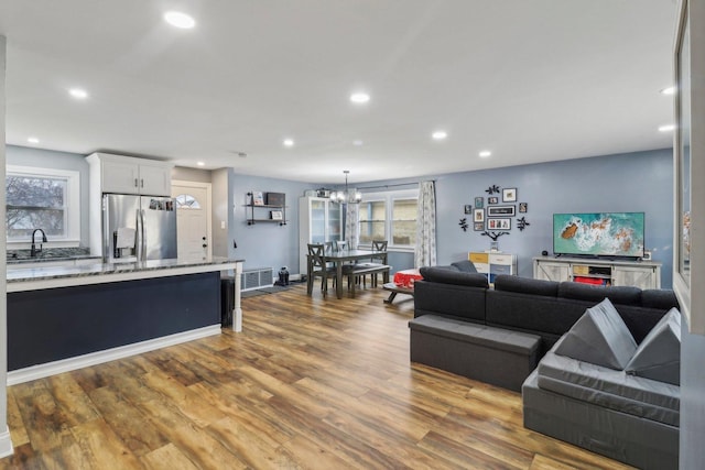 living room with plenty of natural light, wood finished floors, visible vents, and recessed lighting