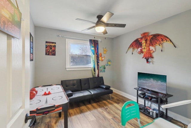 playroom featuring ceiling fan, baseboards, and wood finished floors