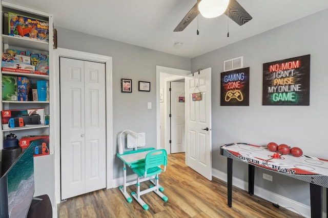 game room with visible vents, wood finished floors, a ceiling fan, and baseboards