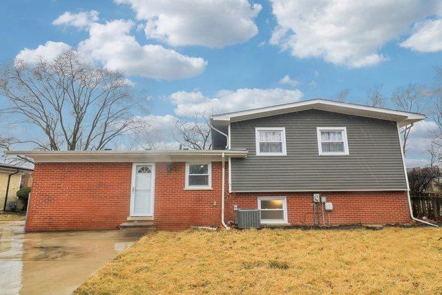 view of front of home with entry steps, a front lawn, central AC unit, and brick siding