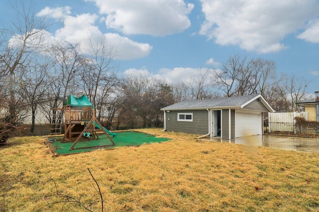 view of jungle gym with a yard, an outdoor structure, and fence