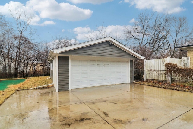 detached garage featuring fence