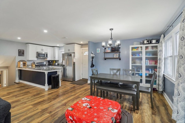 dining room with dark wood-style floors, recessed lighting, baseboards, and an inviting chandelier