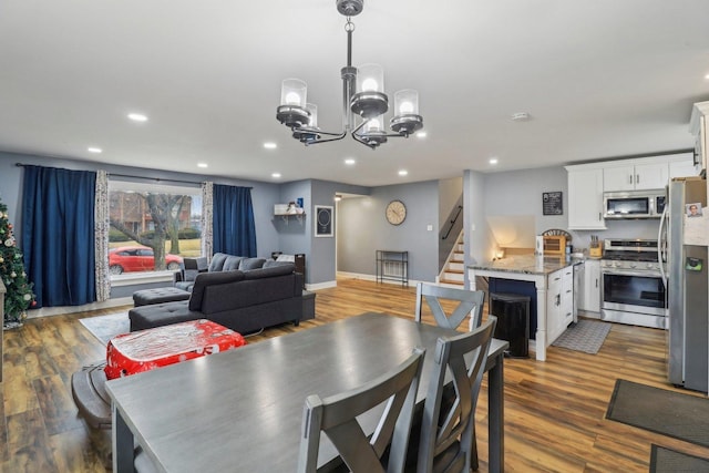 dining space with baseboards, stairway, wood finished floors, and recessed lighting