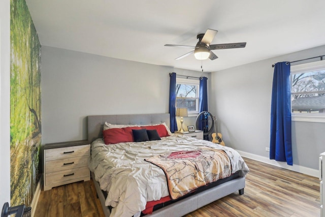 bedroom featuring wood finished floors, a ceiling fan, and baseboards