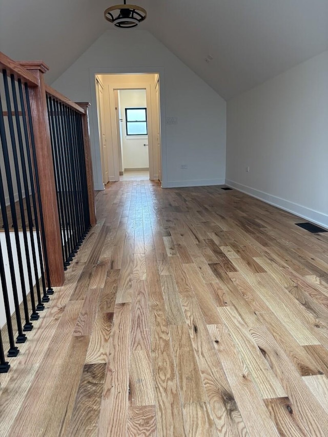 bonus room with baseboards, visible vents, light wood-style flooring, and lofted ceiling