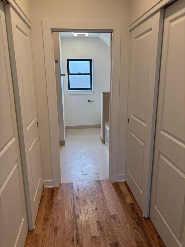 hallway with baseboards and light wood-style floors