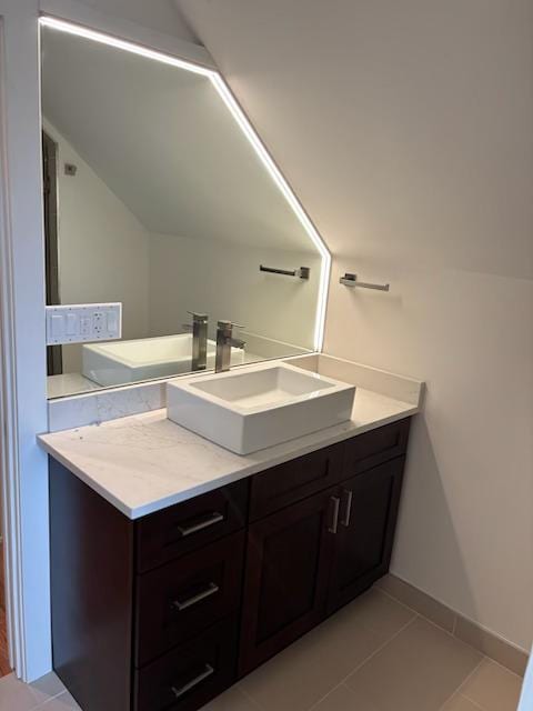 bathroom with tile patterned floors, baseboards, and vanity