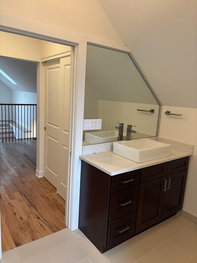 bathroom featuring vaulted ceiling, wood finished floors, and vanity