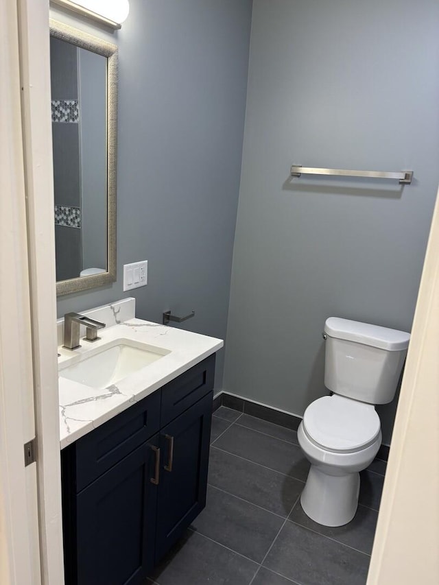 bathroom featuring baseboards, toilet, tile patterned flooring, and vanity
