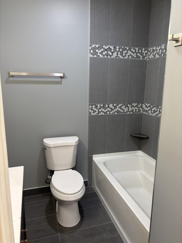full bath featuring baseboards, toilet, tile patterned flooring, and shower / bath combination