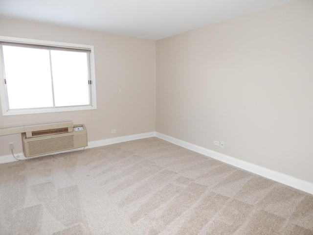 carpeted empty room with baseboards and a wall unit AC