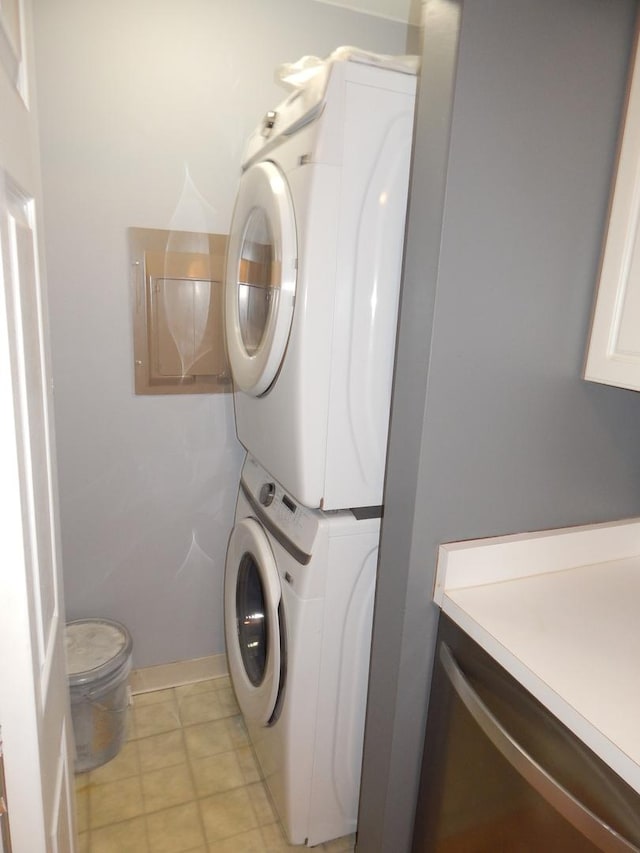 laundry room with laundry area, baseboards, and stacked washing maching and dryer