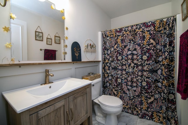 bathroom featuring toilet, marble finish floor, curtained shower, and vanity