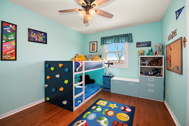 bedroom featuring dark wood-style flooring, a ceiling fan, and baseboards