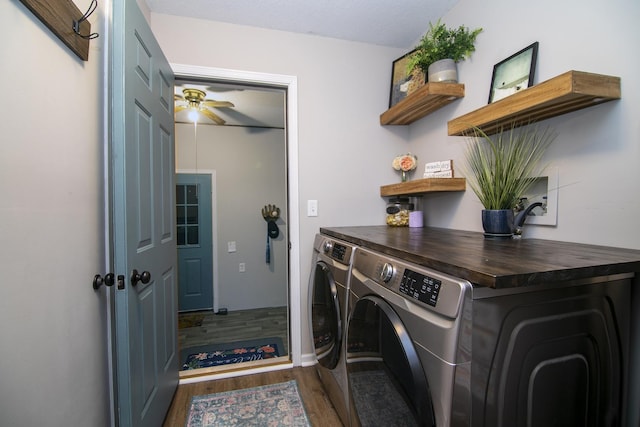 clothes washing area with dark wood-style floors, laundry area, ceiling fan, and washer and dryer