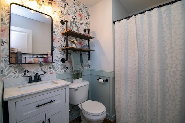 bathroom featuring wainscoting, vanity, and toilet