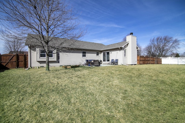 rear view of property with a yard, a chimney, a shingled roof, a patio area, and a fenced backyard