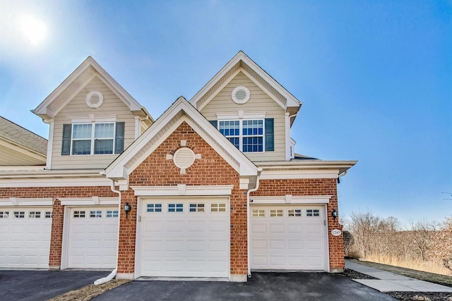 view of front facade featuring a garage, aphalt driveway, and brick siding