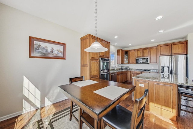 dining room featuring baseboards, wood finished floors, and recessed lighting