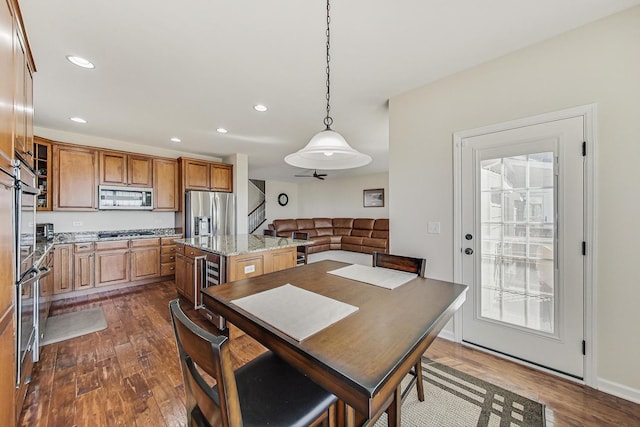 dining area with dark wood-type flooring, wine cooler, and recessed lighting