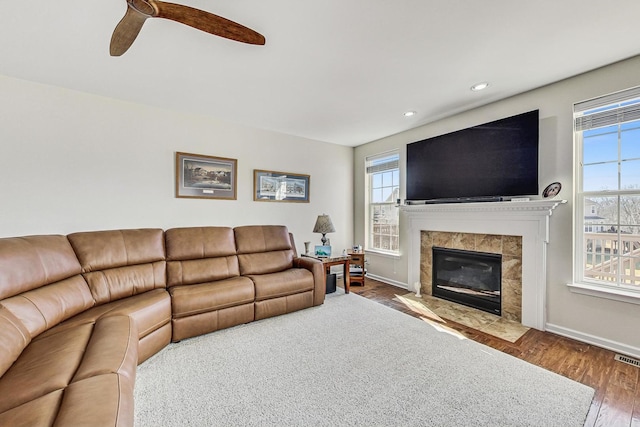 living area with recessed lighting, a fireplace, wood finished floors, and baseboards