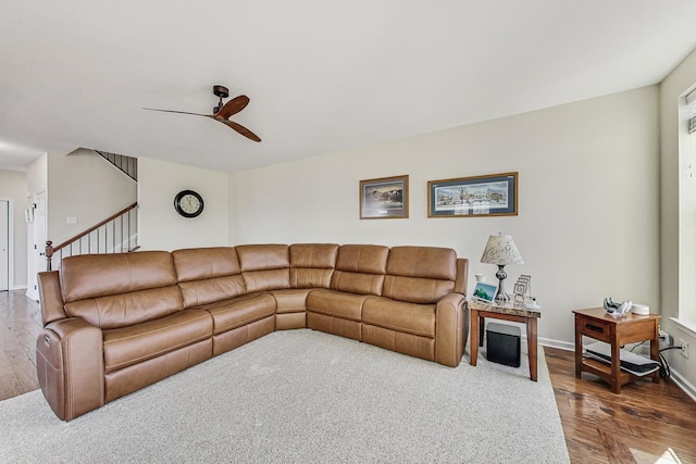 living area with plenty of natural light, baseboards, dark wood finished floors, ceiling fan, and stairway